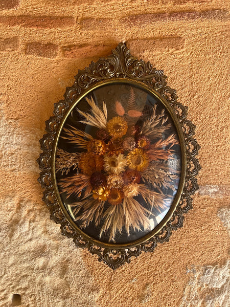 Cadre en métal patiné vintage de fleurs séchées au verre bombé.